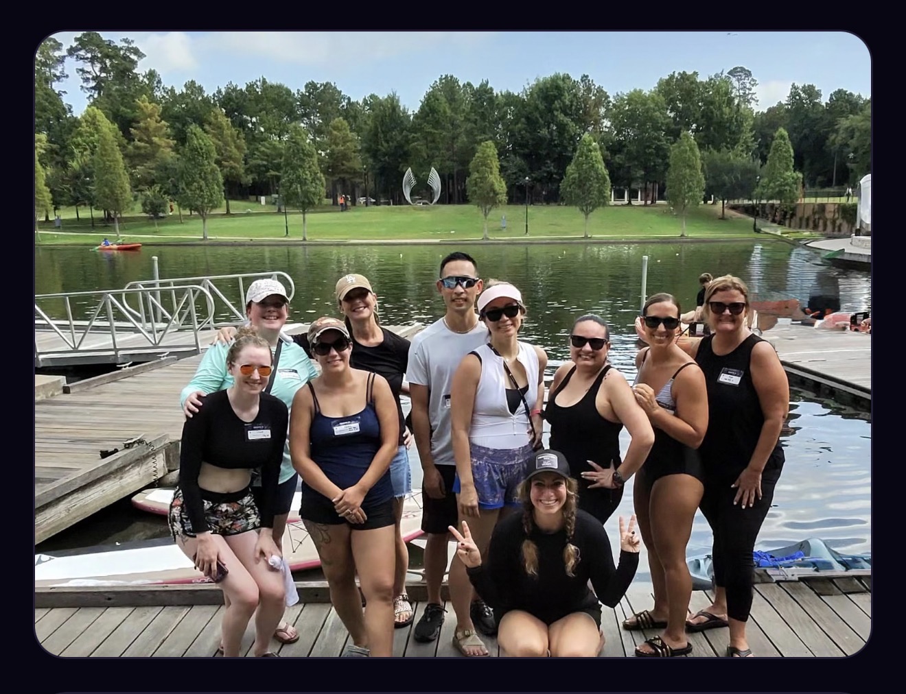 A group of Generation Zen paddlers smiling together on the dock after a class