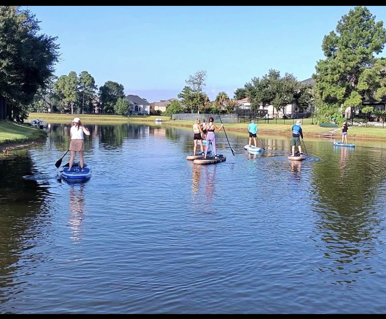 Paddle Crew members paddling laps on a neighborhood lake in The Woodlands